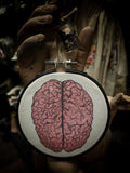 Human brain embroidery with mummified brain vial